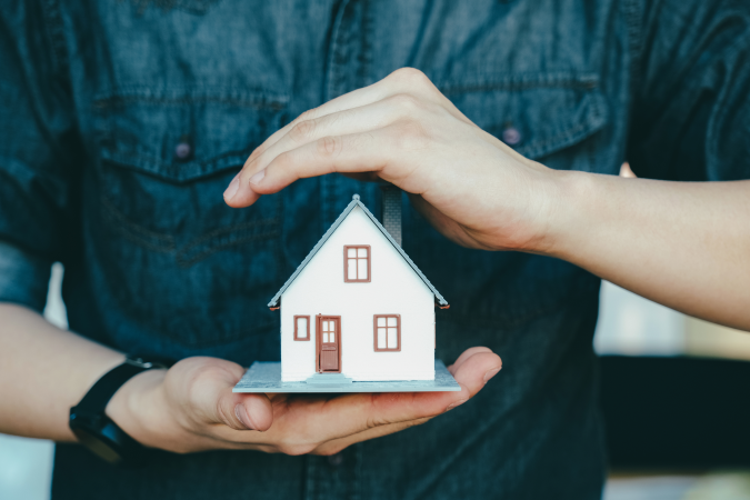 hands holding paper house